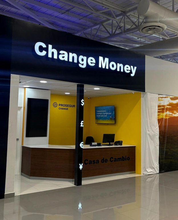 Imagen en primer plano de la oficina de Prosegur Change ubicada en la nueva salida de pasajeros 2 del Aeropuerto Internacional de El Salvador, con el mostrador de atención, la señalización Change Money y los colores corporativos visibles.